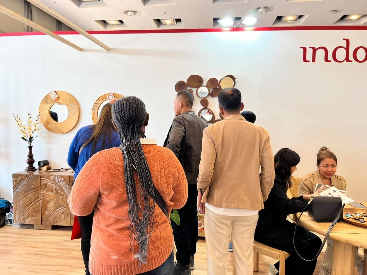 Visitors gathering at the Indonesia Pavilion with teak furniture and wooden mirrors on display