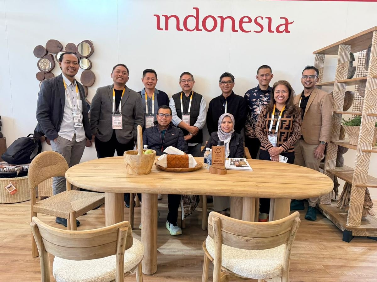 Indonesian exhibitor team around a solid teak table at the Indonesia Pavilion, Decorex Johannesburg 2026