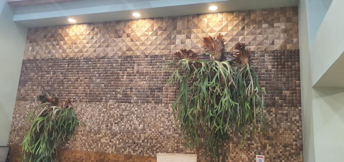 Coconut shell mosaic feature wall with a pyramid pattern band and staghorn ferns, Karya Kreatif Indonesia 2026, JICC Jakarta