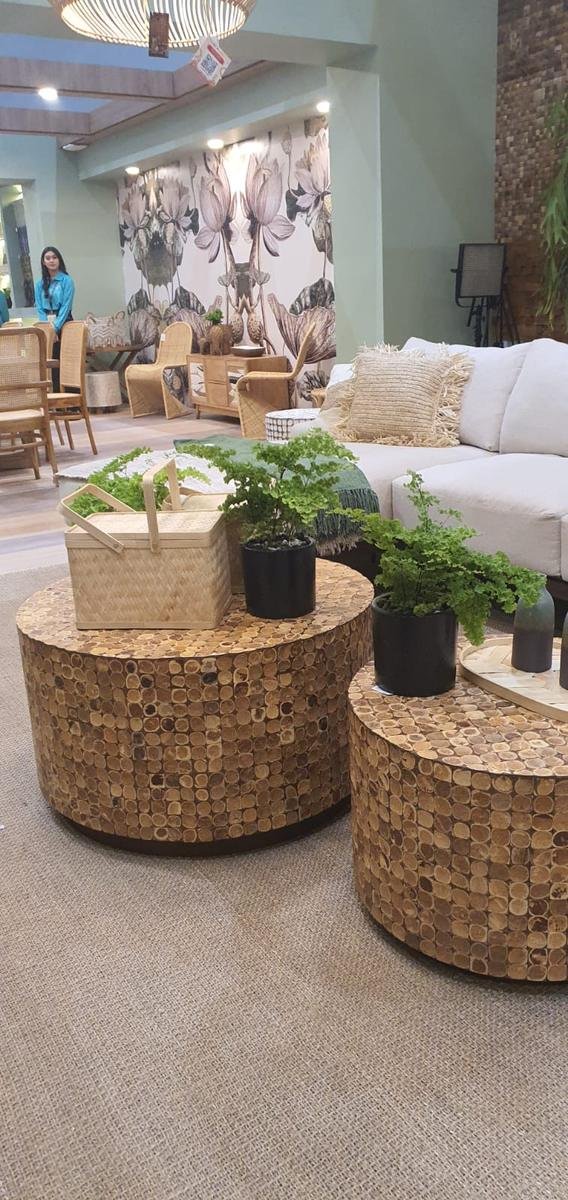 Set of two round Cocora coconut shell mosaic coffee tables styled with ferns and a bamboo basket, KKI 2026