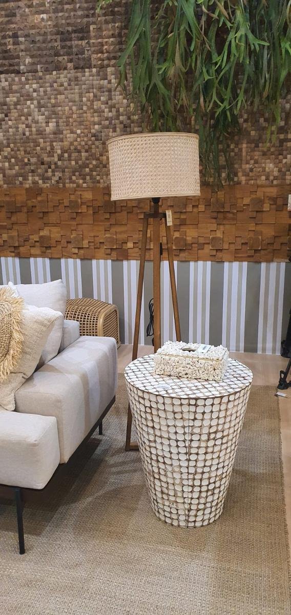 White coconut shell mosaic side table next to a sofa and tripod floor lamp, teak block wall panels behind, KKI 2026