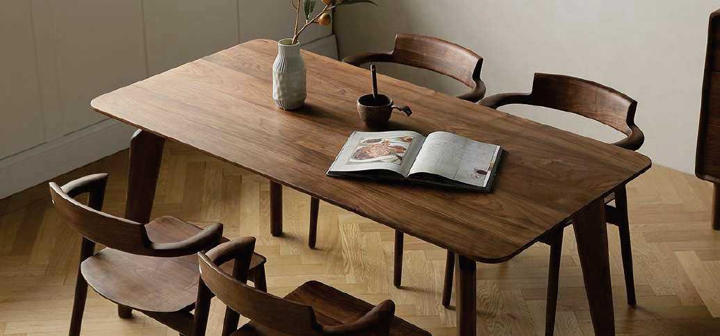 Teak dining table with matching chairs in a bright dining room
