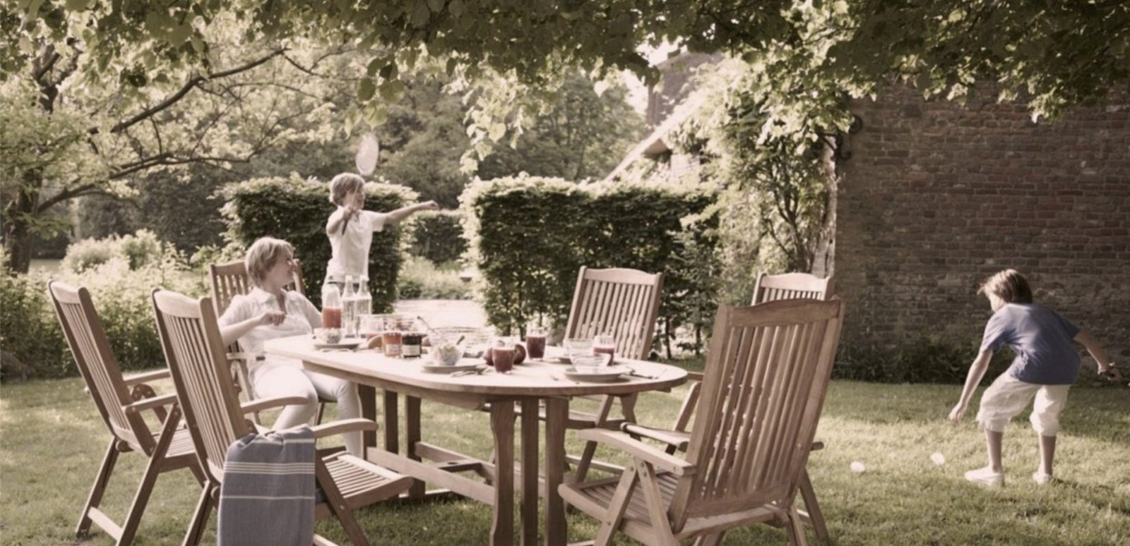 Teak garden dining set with folding chairs under the trees