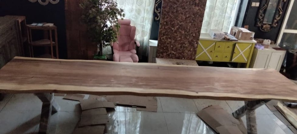 Live-edge Suar conference table in the finishing area